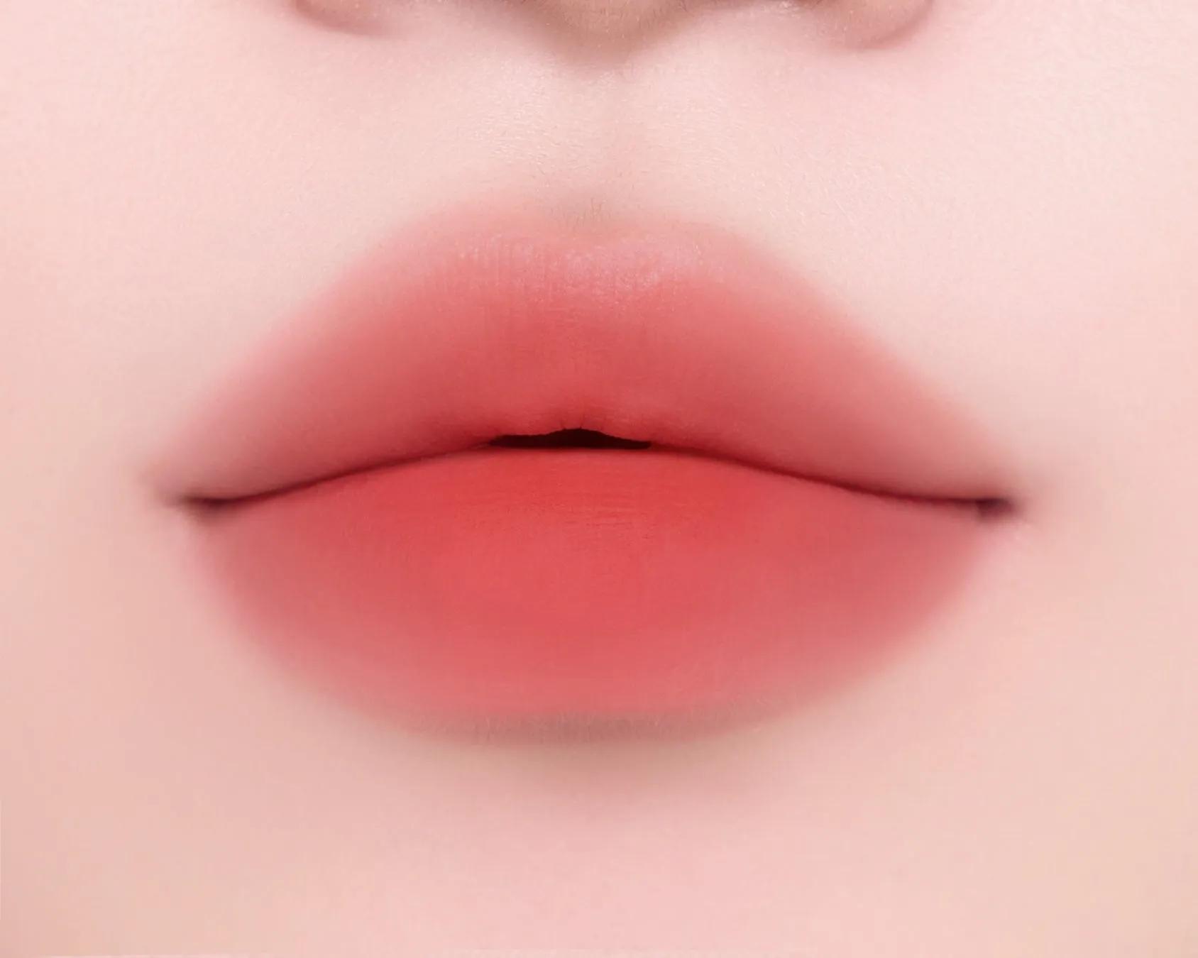 唇のアップ。鮮やかなオレンジ色のリップスティックが塗られている.