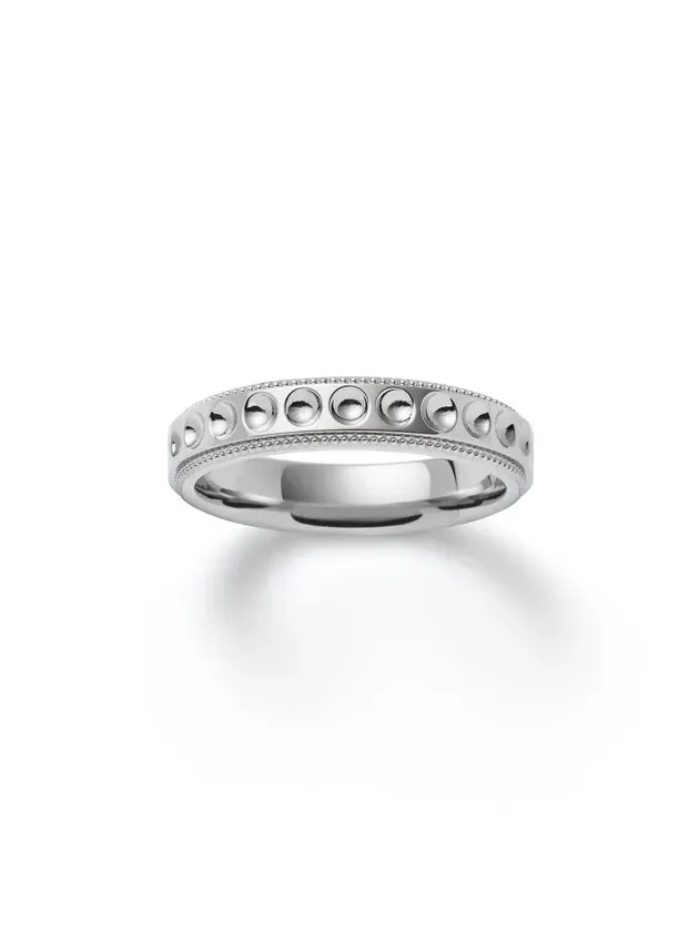 白い背景に置かれた、シルバーの指輪の写真です。指輪には、小さな丸い装飾が施されています。