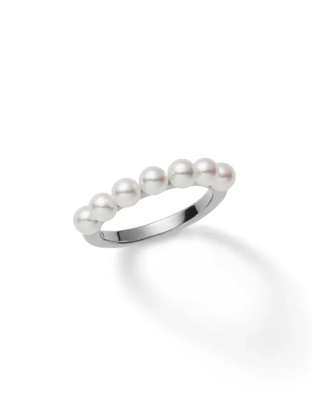 白い背景に、真珠が7つ並んだ指輪のクローズアップ写真。
