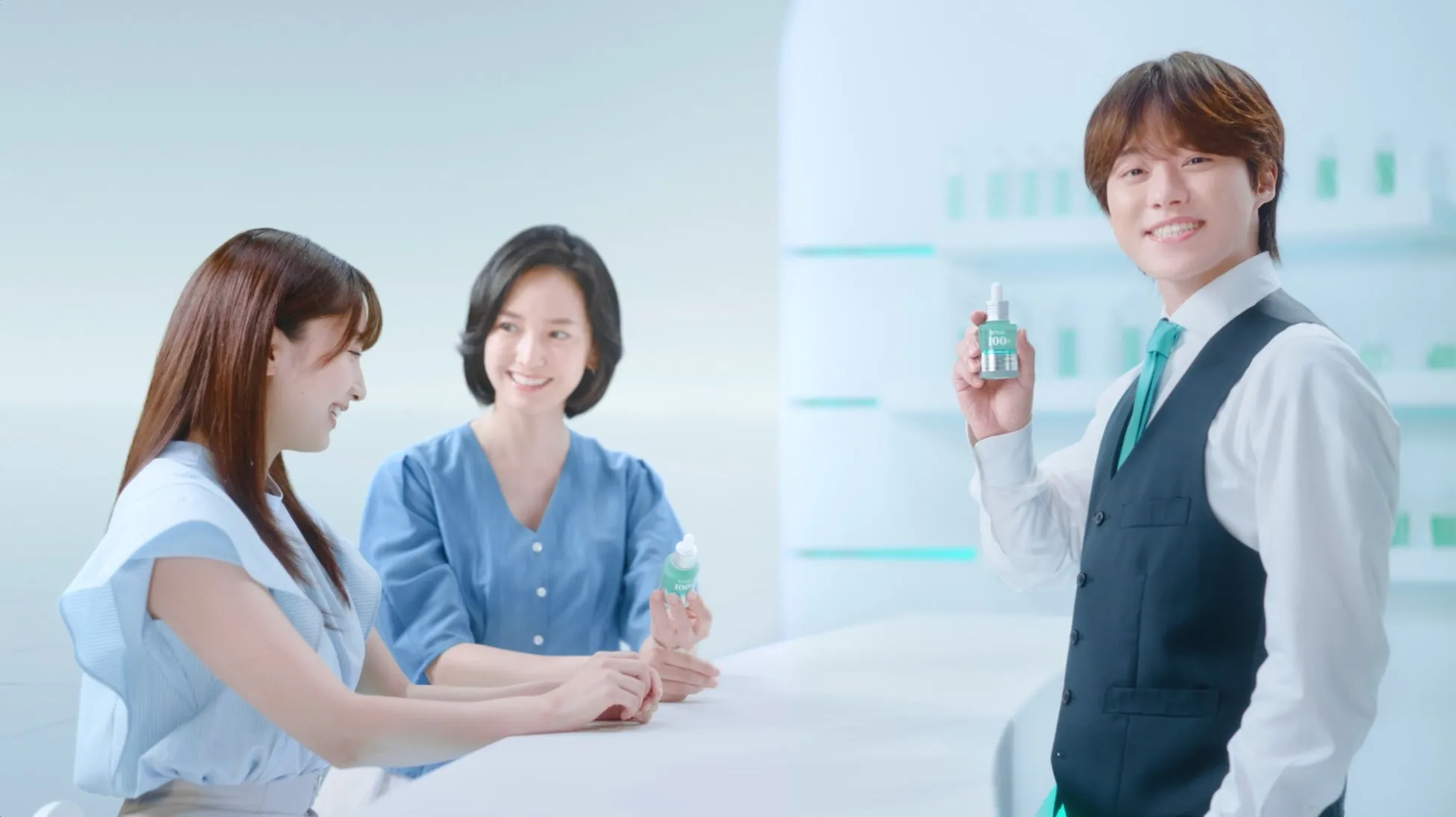 男性が商品を紹介している様子。女性2人がそれを見ている。