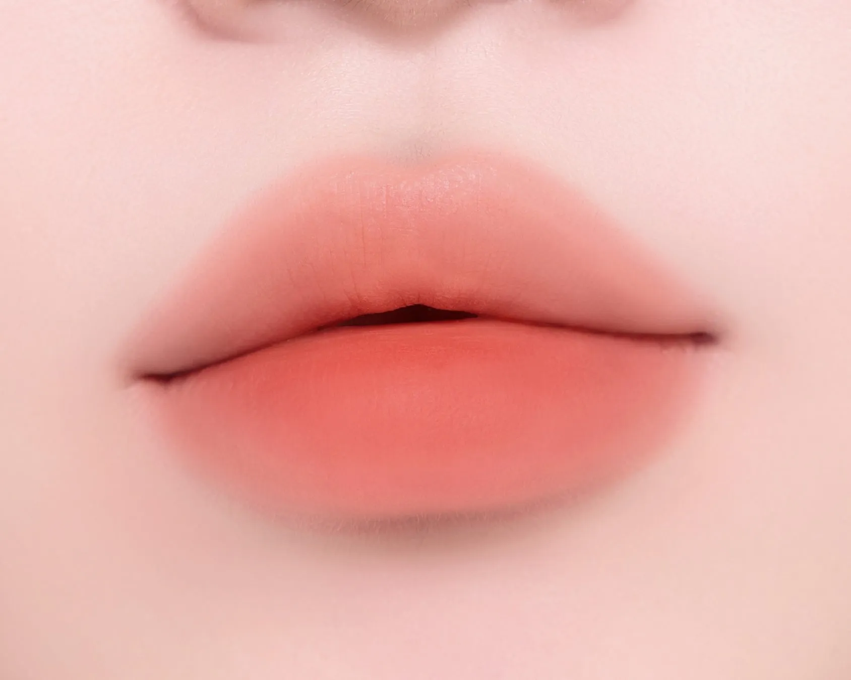 唇のクローズアップ写真。唇はオレンジがかったピンク色で、ぼやけた効果があります.