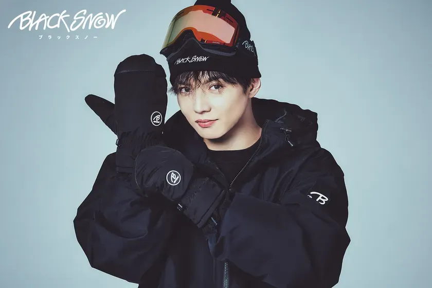 スキーウェアを着た男性の広告写真。男性はスキーゴーグルと帽子を着用し、ウィンタースポーツの準備をしている様子。