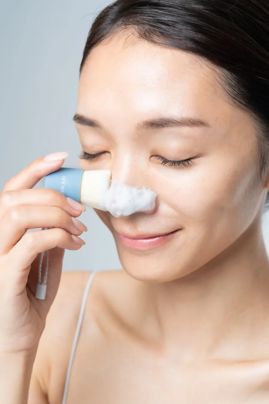 女性が洗顔ブラシを使って鼻を洗っている様子。