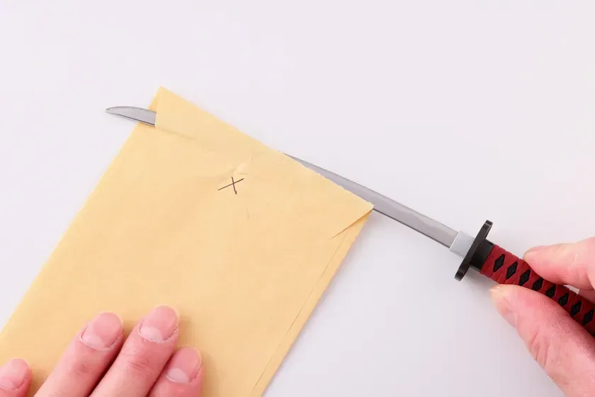 手紙を刀で切る様子を写した写真